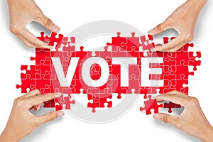 Hands arrange puzzle with vote text