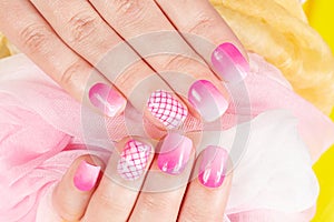 Hands with artificial manicured nails ombre gradient design in pink and white colors
