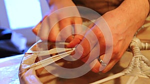 Hands of an artisan making sacred drum.