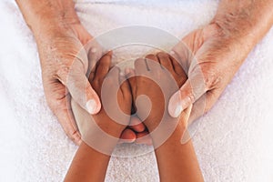 Hands of asian child girl holding elderly grandparent hands wrinkled skin