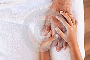 Hands of asian child girl holding elderly grandparent hands wrinkled skin