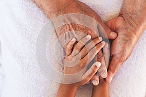 Hands of asian child girl holding elderly grandparent hands wrinkled skin