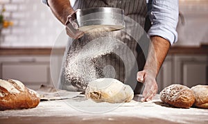 Hands of baker`s male knead dough