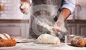 Hands of baker`s male knead dough