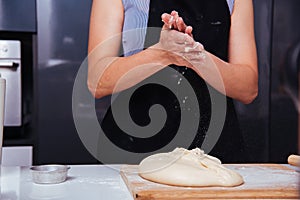 Hands of baker woman female making clapping flour dough