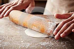 Hands baking dough with rolling pin photo