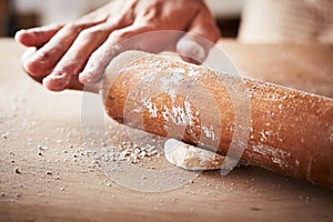 Hands baking dough with rolling pin photo