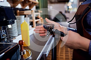 Hands baristas make at the cappuccino machine in the bar