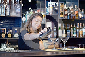 The hands of a bartender woman hold a professional shaker photo