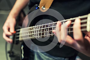 Hands the bass player. Closeup. Playing the guitar. Selective fo