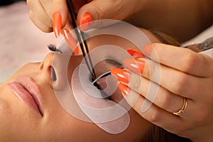 Hands Of Beautician Using Tweezers For Applying False Eyelashes
