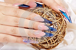 Hands with beautiful long artificial blue french manicured nails