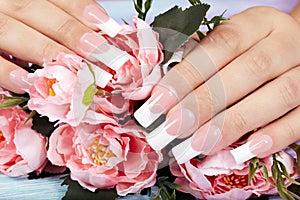 Hands with beautiful long artificial french manicured nails