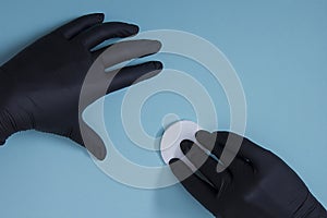 Hands in black nitrile gloves