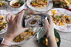 Hands of a blogger taking a photo of healthy food to share on social networks