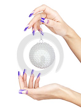 Hands with blue french false acrylic nails manicure holding perl christmas ball