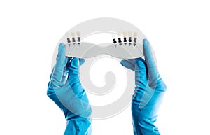 Hands in blue gloves holding dental color palette isolated