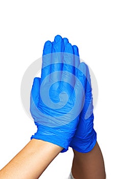 Hands in blue latex medical gloves folded together indicating the process of prayer.