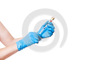 Hands in blue medical gloves holding glass bottle fulled with a vaccine different pills.