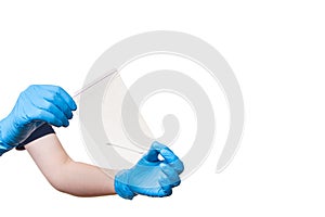 Hands in blue sterile gloves hold a sealed bag with a cotton swab.