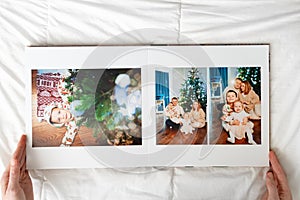 hands with book with new year photos of big family at home on a white background