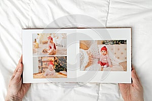 a hands with a book with photos of little child on a white background.