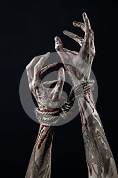 Hands bound,bloody hands, mud, rope, on a black background, isolated, kidnapping, zombie, demon