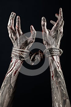 Hands bound,bloody hands, mud, rope, on a black background, isolated, kidnapping, zombie, demon