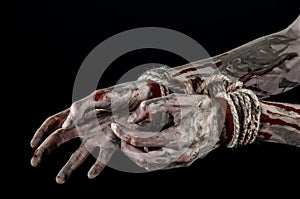 Hands bound,bloody hands, mud, rope, on a black background, isolated, kidnapping, zombie, demon