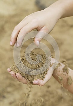 Hands of child playing in the sand