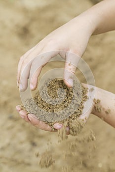 Hands of child playing in the sand