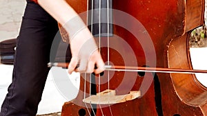 Hands of boy playing the violin in the street closeup