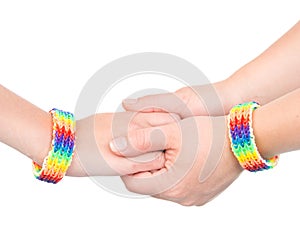 hands with a bracelet patterned as the rainbow flag. isolated on white