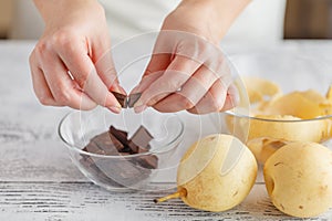 Hands breaking a chocolate in bowl