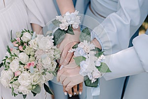 Hands of the bride and bridesmaids with flowers