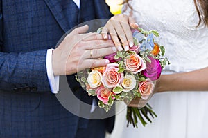 Hands of bride and grom with golden wedding rings