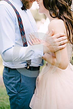 Hands of the bride and groom hugging tenderly, close-up