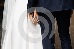 Hands of bride and groom. New young couple holding hands after their wedding. Young married couple holding hands, ceremony wedding