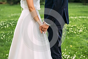 Hands of bride and groom. New young couple holding hands after their wedding. Young married couple holding hands, ceremony wedding