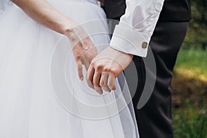 Hands of bride and groom. New young couple holding hands after their wedding. Young married couple holding hands, ceremony wedding