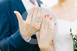 Hands of bride and groom with rings.