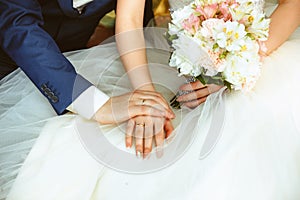 Hands of the bride and groom with rings wedding bouquet.