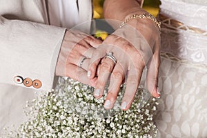 Hands of the bride and groom showing their wedding rings
