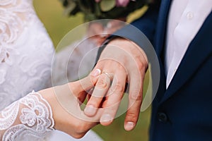 Hands of bride and groom wearing a wedding ring. Marriage ceremony. Newlyweds