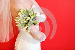 Hands of bride hold bouquet