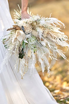 hands of the bride holding beautiful autumn bouquet