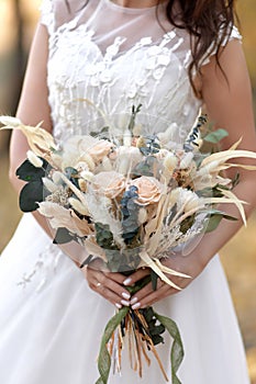 hands of the bride holding beautiful autumn bouquet