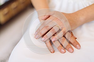 Hands of a bride, placed on her lap, woman waiting