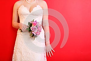 Hands of bride wearing dress hold bouquet