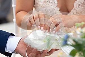 Hands of the bride during the wedding as they take the wedding ring for the exchange of rings